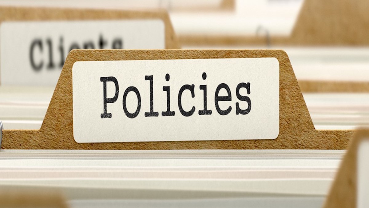 Image of file folders with various labels. The label on the folder in focus says "Policies."